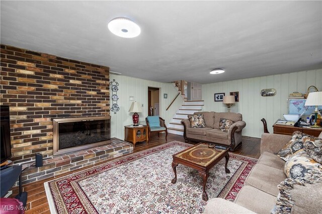 living room featuring stairs, a fireplace, and hardwood / wood-style floors
