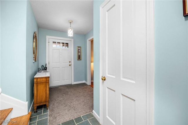 doorway to outside with dark tile patterned flooring, baseboards, and dark colored carpet