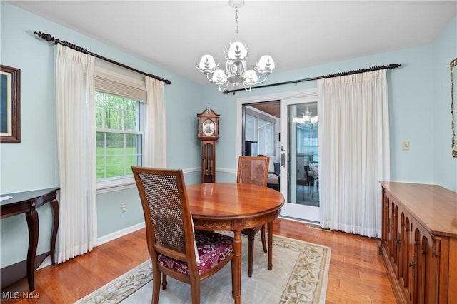 dining space with light wood-style floors and a chandelier
