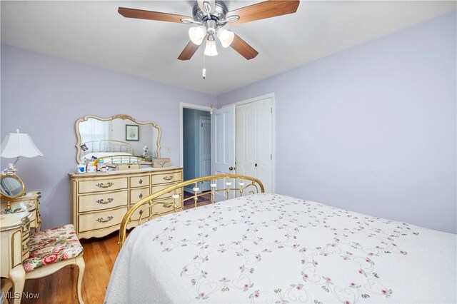 bedroom featuring a ceiling fan, a closet, and wood finished floors