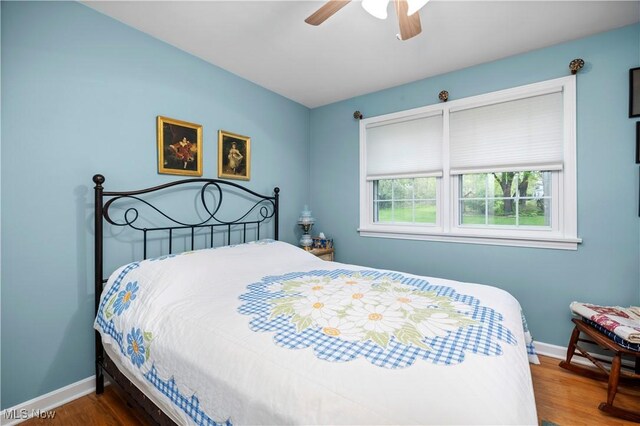 bedroom with baseboards, a ceiling fan, and wood finished floors
