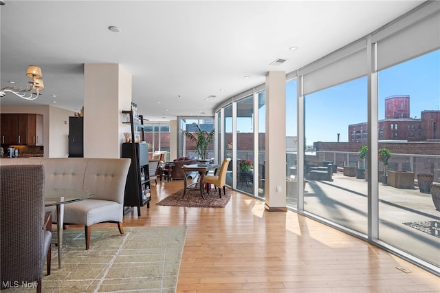 interior space with a notable chandelier, floor to ceiling windows, plenty of natural light, and hardwood / wood-style flooring