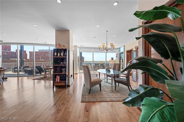dining room featuring a wall of windows, a city view, hardwood / wood-style floors, and a chandelier