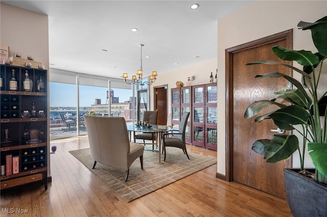 dining space featuring wood-type flooring, a view of city, a chandelier, and recessed lighting