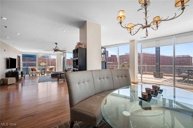 dining room featuring plenty of natural light, floor to ceiling windows, recessed lighting, and wood finished floors