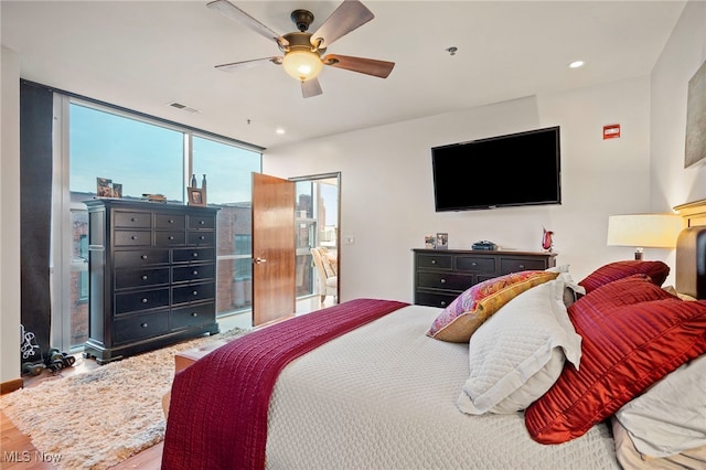 bedroom featuring visible vents, wood finished floors, ceiling fan, recessed lighting, and expansive windows