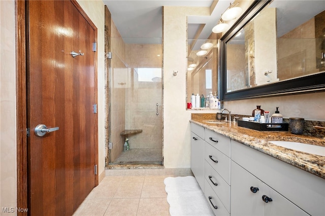 bathroom featuring a sink, tile patterned floors, a stall shower, and double vanity