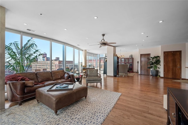 living room featuring visible vents, a view of city, recessed lighting, a ceiling fan, and light wood finished floors