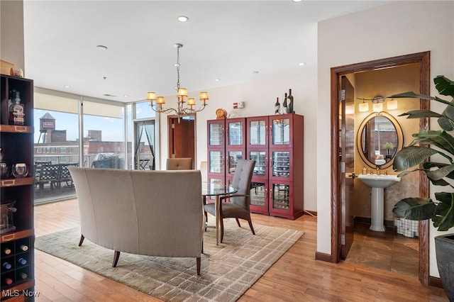 dining room with wood-type flooring, recessed lighting, and a notable chandelier