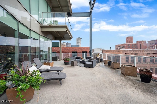 view of patio with outdoor lounge area, a city view, and a balcony