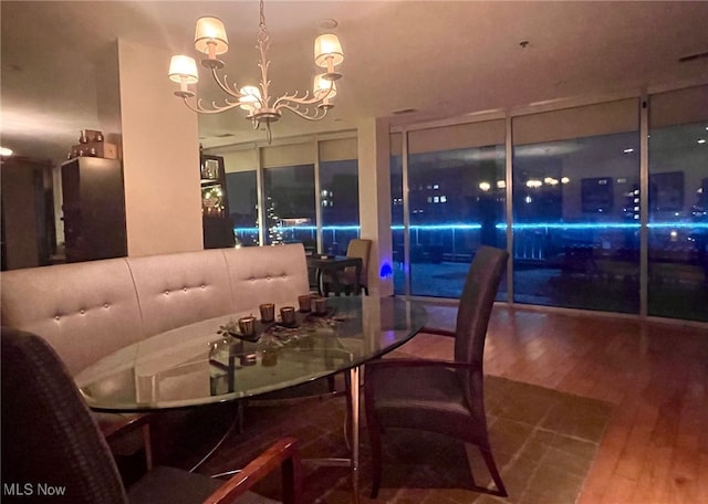 dining room with wood finished floors and a chandelier