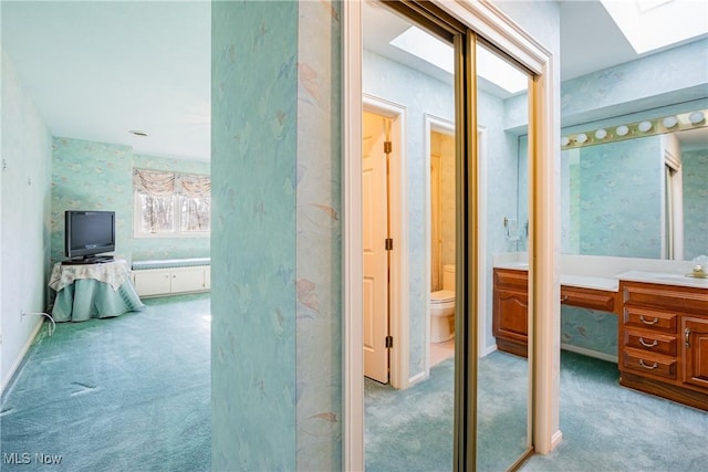 1175 Inverness Ln, Stow, OH 44224 - interior space featuring vanity, toilet, wallpapered walls, baseboards, and a skylight