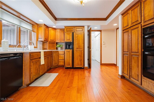 1175 Inverness Ln, Stow, OH 44224 - kitchen featuring crown molding, brown cabinetry, light wood-type flooring, a tray ceiling, and black appliances