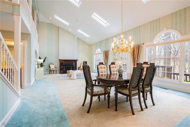 1175 Inverness Ln, Stow, OH 44224 - carpeted dining area with an inviting chandelier, high vaulted ceiling, stairs, wallpapered walls, and visible vents