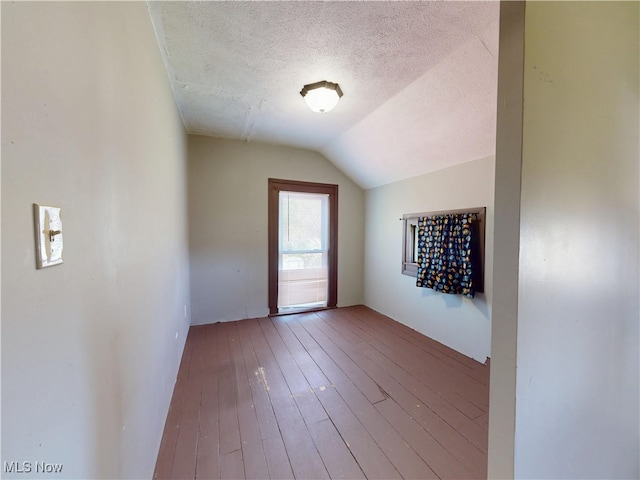 bonus room featuring wood-type flooring, a textured ceiling, and vaulted ceiling