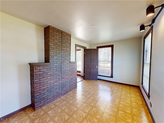 spare room with baseboards and light floors