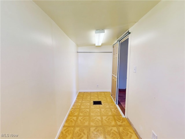 hall with baseboards and visible vents