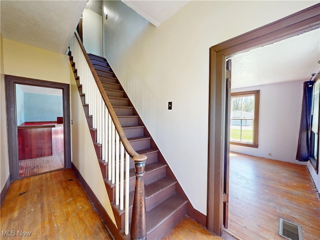 staircase featuring visible vents and hardwood / wood-style flooring