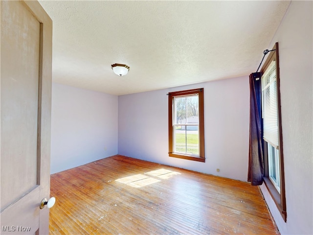 spare room featuring a textured ceiling and hardwood / wood-style floors