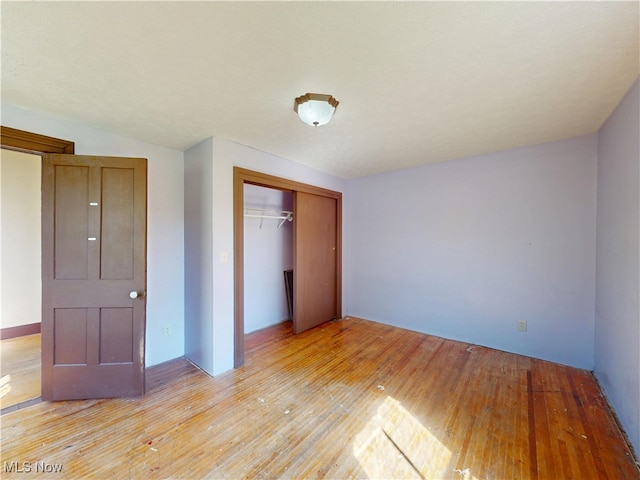 unfurnished bedroom with light wood-style floors and a closet