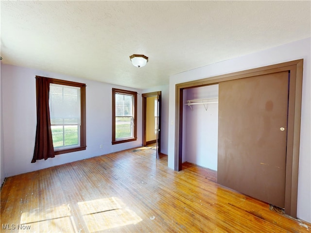 unfurnished bedroom with a closet and light wood finished floors