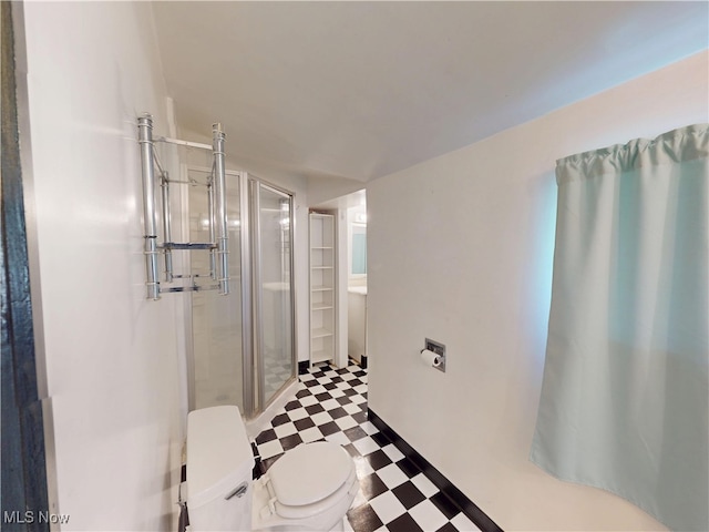 bathroom with toilet, tile patterned floors, and a shower stall