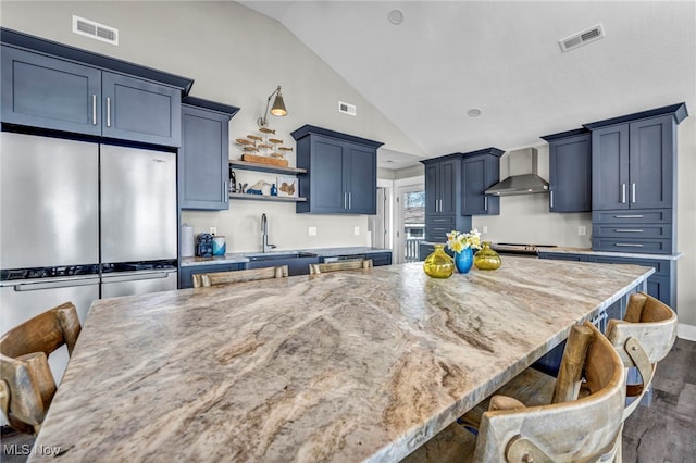 kitchen featuring visible vents, a sink, lofted ceiling, and dark wood-type flooring