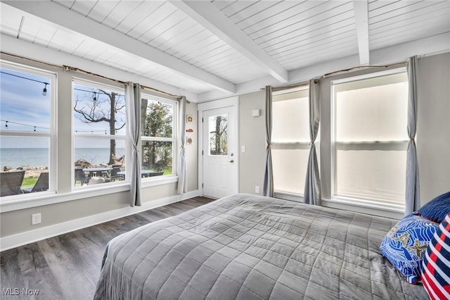 bedroom with a water view, baseboards, wood finished floors, and beam ceiling