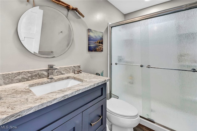 full bath with vanity, toilet, and a shower stall