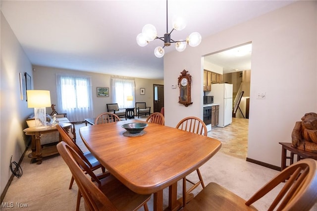 dining area with an inviting chandelier, baseboards, and light colored carpet