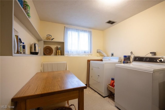 clothes washing area with washing machine and clothes dryer, laundry area, light carpet, and visible vents