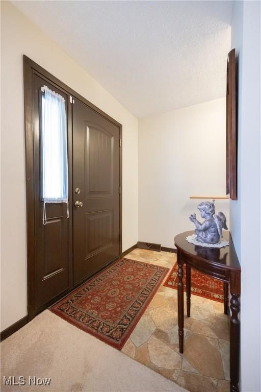 foyer featuring baseboards