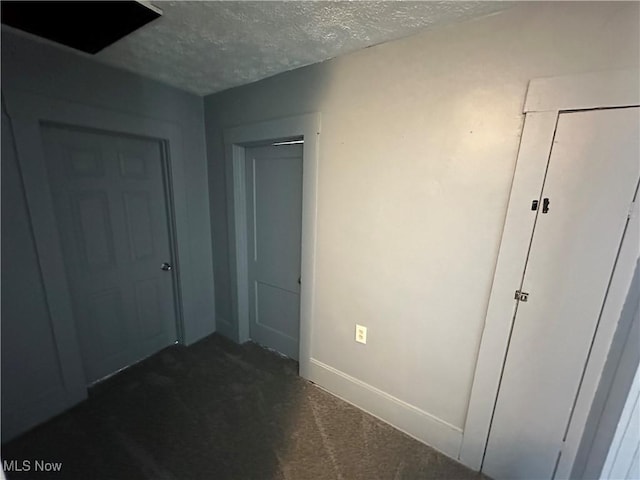 unfurnished bedroom with baseboards, carpet flooring, and a textured ceiling
