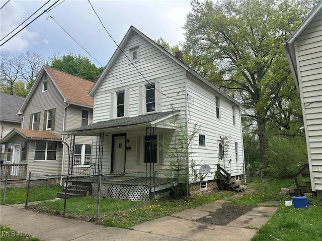 view of front of house with a fenced front yard, covered porch, and a chimney