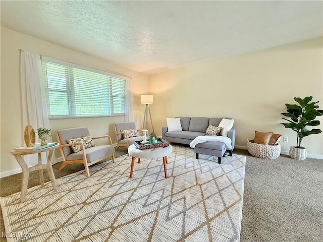 living room with light colored carpet, a textured ceiling, and baseboards
