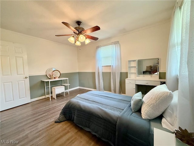 bedroom featuring crown molding, a ceiling fan, baseboards, and wood finished floors