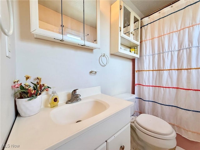full bath with vanity, a shower with curtain, and toilet