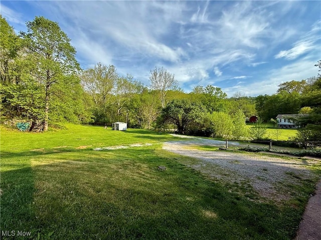 view of home's community featuring a yard, an outbuilding, and a shed