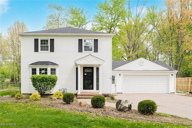 view of front facade with an attached garage, fence, and driveway