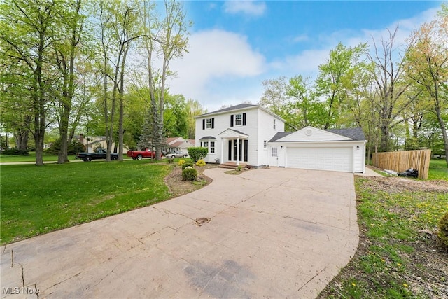 colonial-style house with an attached garage, fence, driveway, and a front yard