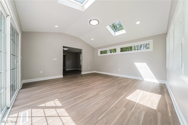 unfurnished room with vaulted ceiling with skylight, visible vents, baseboards, light wood finished floors, and recessed lighting