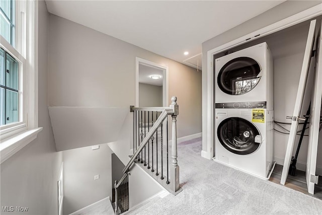 clothes washing area featuring laundry area, attic access, stacked washing maching and dryer, baseboards, and recessed lighting