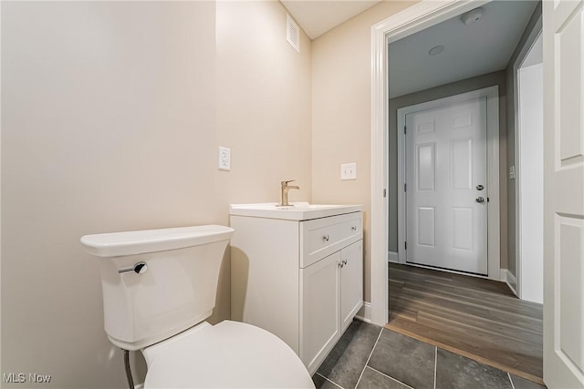 bathroom featuring visible vents, tile patterned flooring, vanity, baseboards, and toilet
