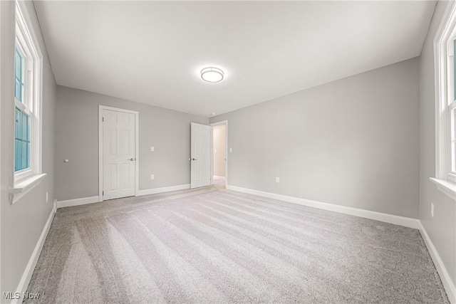 unfurnished bedroom with baseboards and light carpet