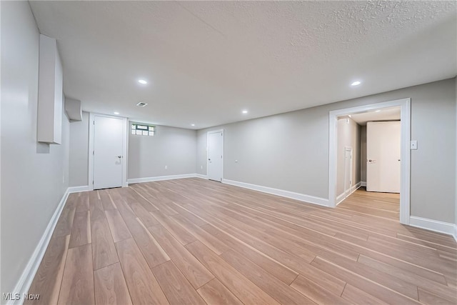 below grade area featuring light wood-type flooring, recessed lighting, and baseboards