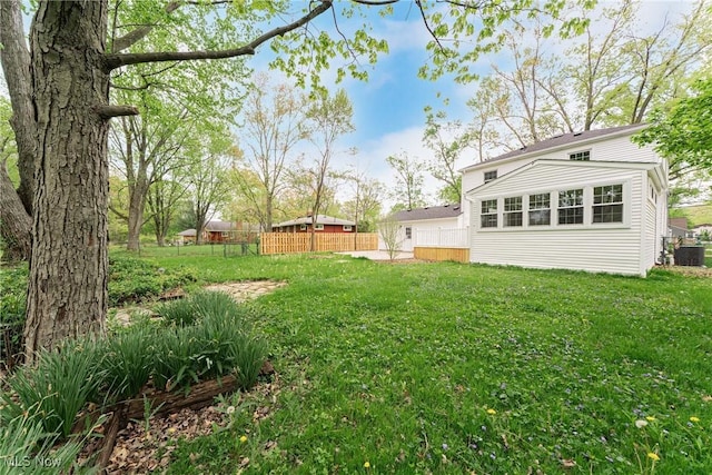 view of yard with fence and central AC unit