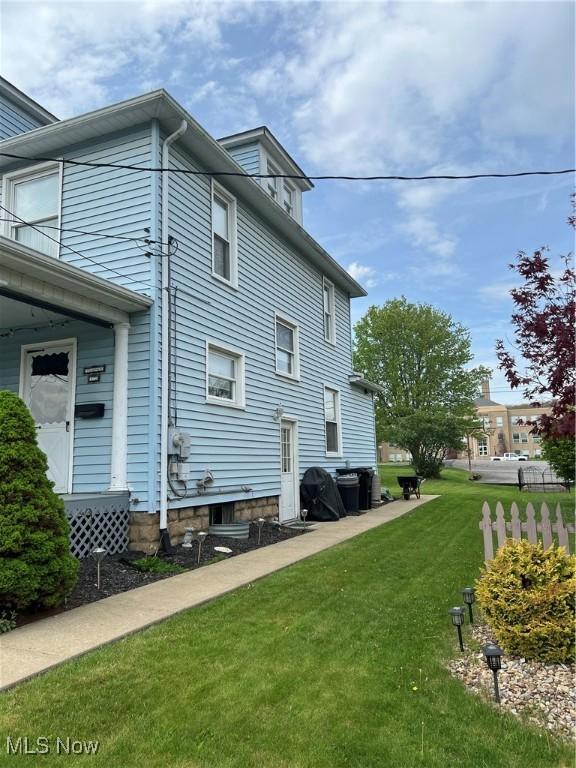 view of side of home with a yard