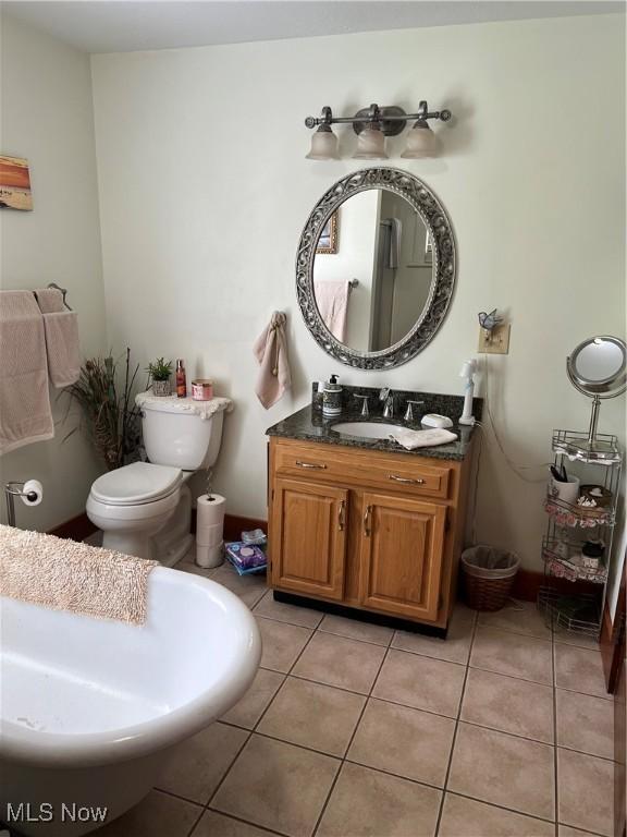 bathroom with vanity, tile patterned flooring, and toilet