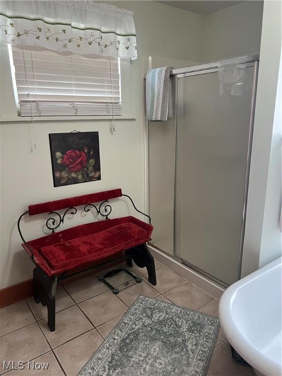 bathroom with baseboards, tile patterned floors, and a stall shower