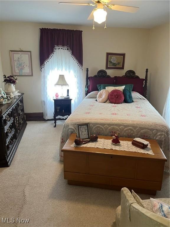 bedroom featuring baseboards, a ceiling fan, and light colored carpet